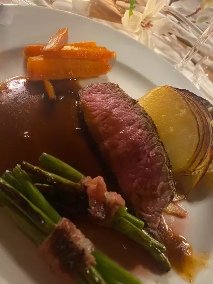 Roast beef with caramelized carrots, bacon-wrapped beans and potato gratin